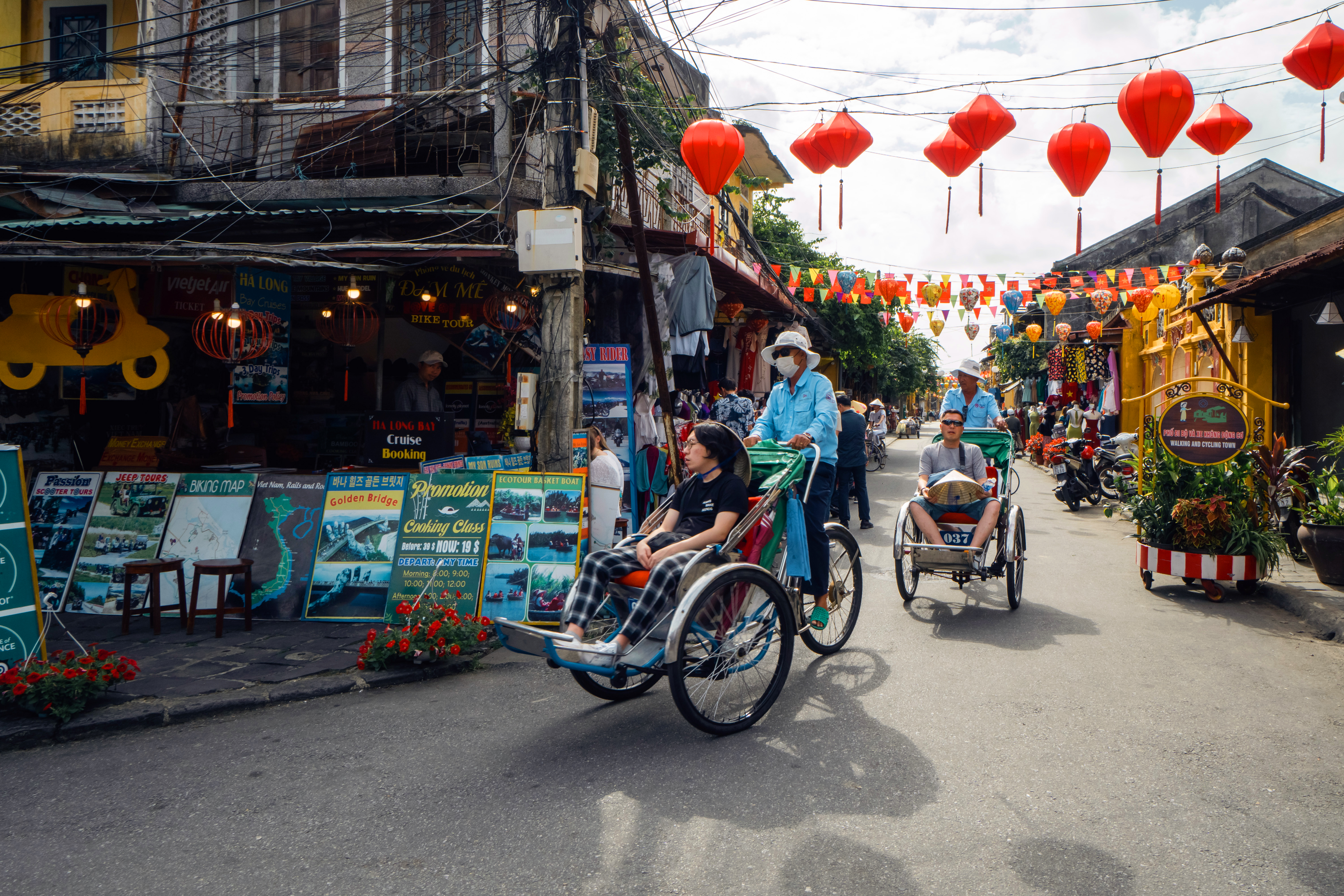 The cyclo driver is carrying a passenger.